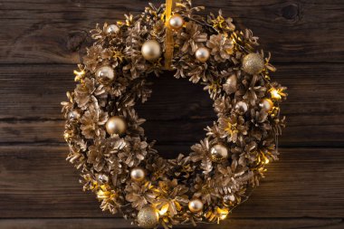 Eski siyah ahşap arka planda Noel altın çelengi 