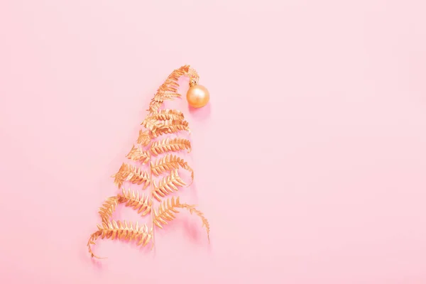 Albero di Natale di felce dipinta con foglie d'oro su carta rosa — Foto Stock