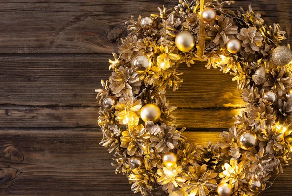 Goldener Weihnachtskranz auf altem dunklem Holzgrund — Stockfoto