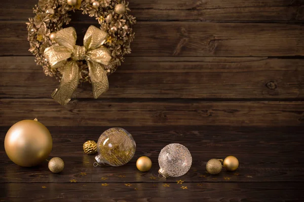 Jul gyllene bollar och krans på mörkt trä bakgrund — Stockfoto