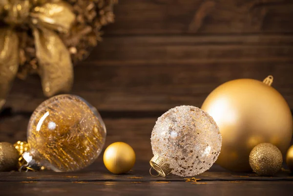 Weihnachten goldene Kugeln und Kranz auf dunklem Holzgrund — Stockfoto