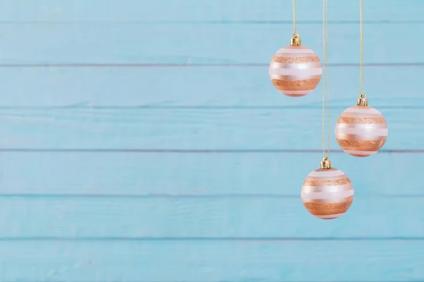 Weihnachtskugeln hängen auf blauem Holzhintergrund — Stockfoto
