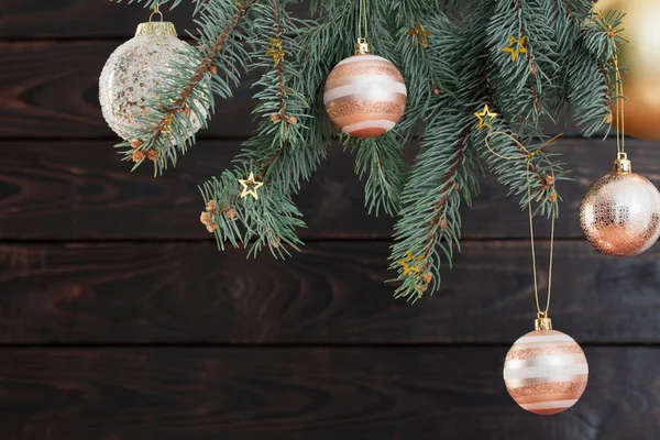 Weihnachtskugeln auf Tannenzweigen auf dunklem Holzgrund — Stockfoto