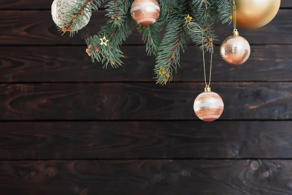 Kerstballen op sparren takken op donkere houten achtergrond — Stockfoto