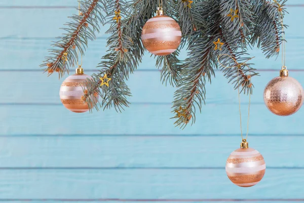 Рождественские шары на еловой ветке на синем деревянном фоне — стоковое фото