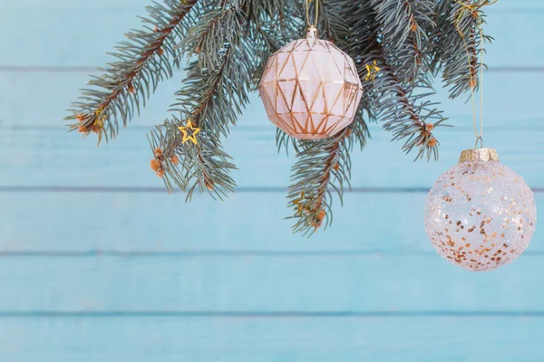 Рождественские шары на еловой ветке на синем деревянном фоне — стоковое фото