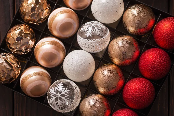 Bolas de Navidad en caja sobre fondo de madera oscura —  Fotos de Stock