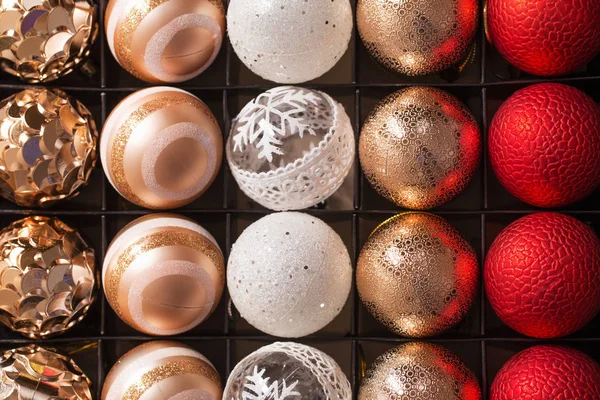 Рождественские красные и золотые шарики в коробке близко — стоковое фото