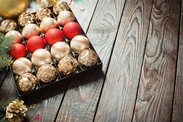 Christmas balls in box on dark wooden background — Stock Photo, Image
