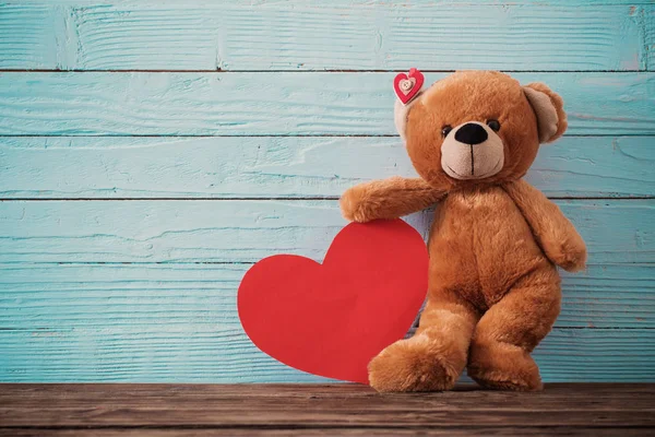 Osito de peluche con corazón rojo sobre fondo de madera viejo. San Valentín —  Fotos de Stock