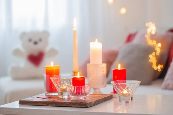 Hořící svíčky na bílém stole v interiéru. Valentines day conce — Stock fotografie