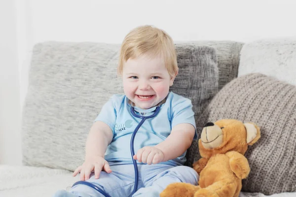 Petit enfant joue médecin avec ours en peluche à la maison — Photo