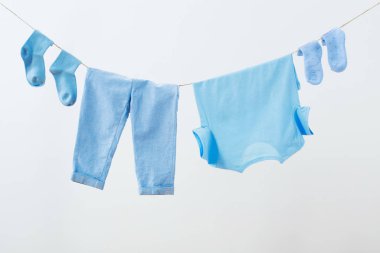 Beyaz arka planda ipe asılı bebek kıyafetleri