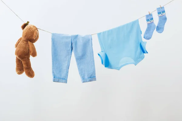 Ropa de bebé colgando de la cuerda sobre fondo blanco — Foto de Stock