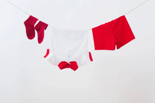 Baby clothes hanging on  rope on white background — Stock Photo, Image