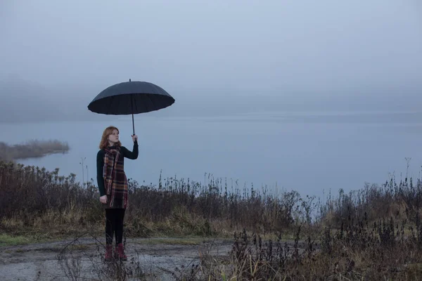Fiatal lány fekete esernyő háttér sötét foogy tó — Stock Fotó