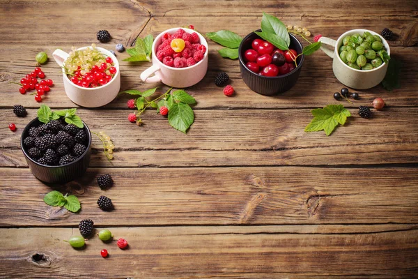 Verschiedene Beeren auf altem Holzgrund — Stockfoto