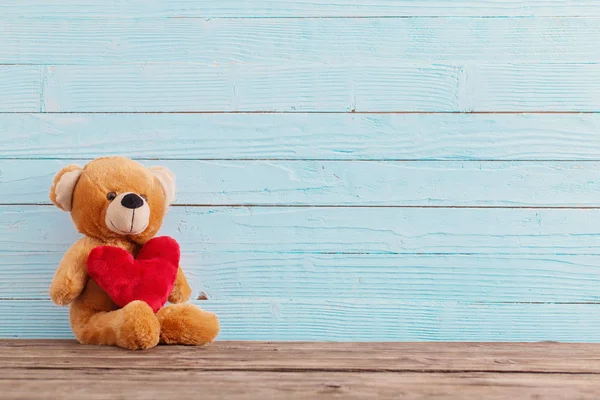 Osito de peluche con corazón rojo sobre fondo de madera viejo. San Valentín —  Fotos de Stock