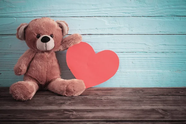 Тедді має червоне серце на старому дерев'яному тлі. Валентинів — стокове фото