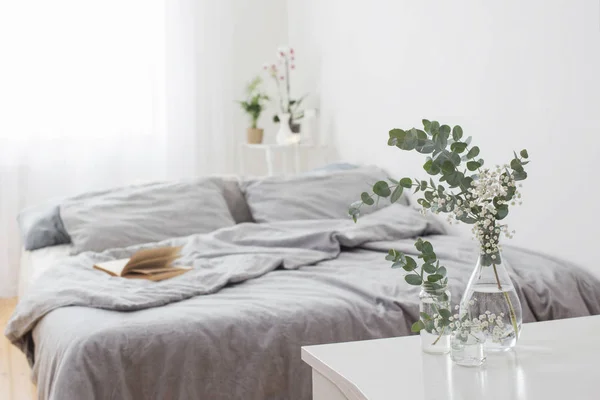 Eukaliptusa w szklanym wazonie w białej sypialni — Zdjęcie stockowe