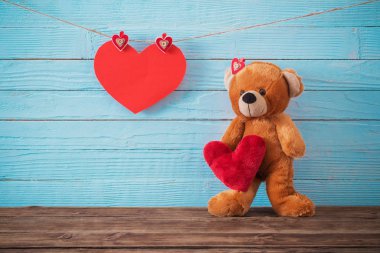 Ahşap arka planda kırmızı kalpli oyuncak ayı. Sevgililer Günü 