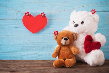 Ahşap arka planda kırmızı kalpli oyuncak ayı. Sevgililer Günü 