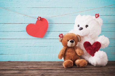 Ahşap arka planda kırmızı kalpli oyuncak ayı. Sevgililer Günü 