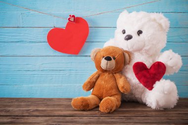 Ahşap arka planda kırmızı kalpli oyuncak ayı. Sevgililer Günü 