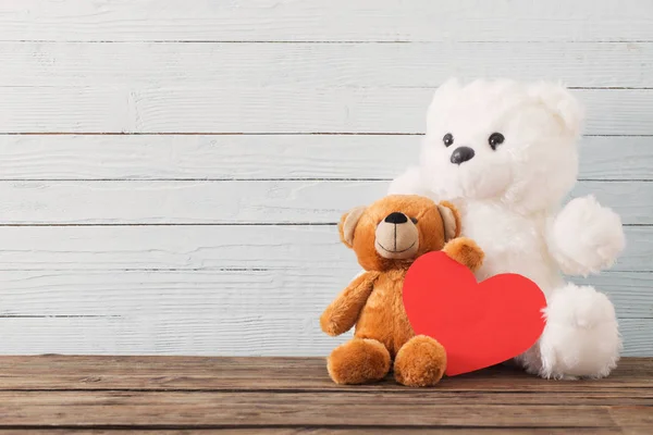 Teddybjörn med rött hjärta på gammal trä bakgrund. Alla hjärtans dag — Stockfoto