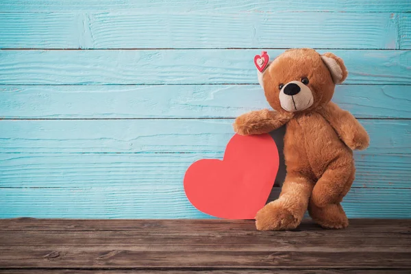 Osito de peluche con corazón rojo sobre fondo de madera viejo. San Valentín —  Fotos de Stock