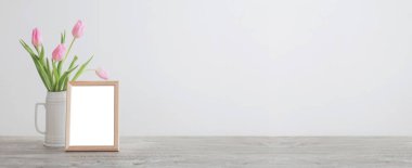 ahşap çerçeve ve beyaz seramik vazoda pembe laleler