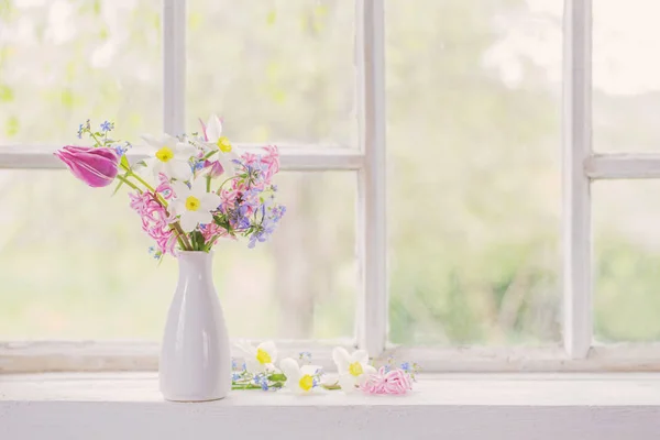 오래 된 창턱에 있는 하얀 꽃병 속의 봄 꽃들 — 스톡 사진