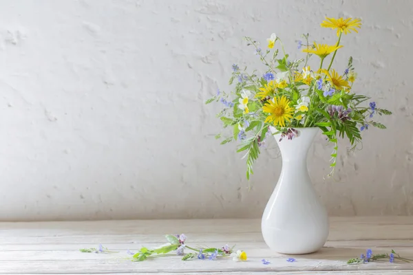 背景墙上白色花瓶里的野花 — 图库照片