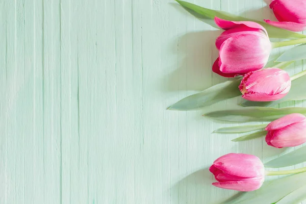 Tulipanes rosados sobre fondo de madera verde — Foto de Stock