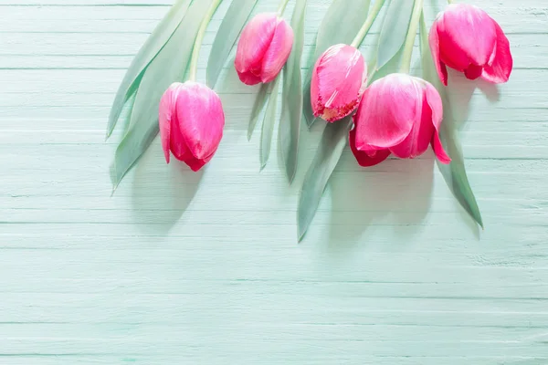 Różowe tulipany na zielonym drewnianym tle — Zdjęcie stockowe