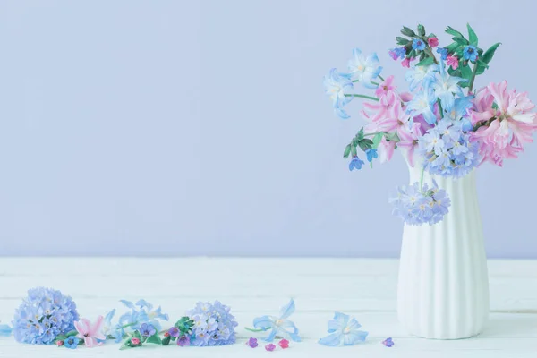 青とピンクの春の花が青のテーブルの上の花瓶に — ストック写真