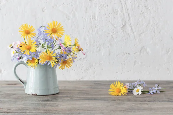 Lente bloemen in Vintage kruik op houten tafel — Stockfoto