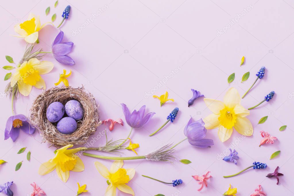 Easter eggs in nest with spring flowers