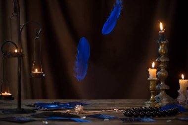 blue falling bird feathers over  wooden table with fortunetellin