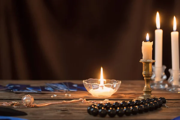 Fortune-telling cards and burning candles on a wooden table on — Stockfoto