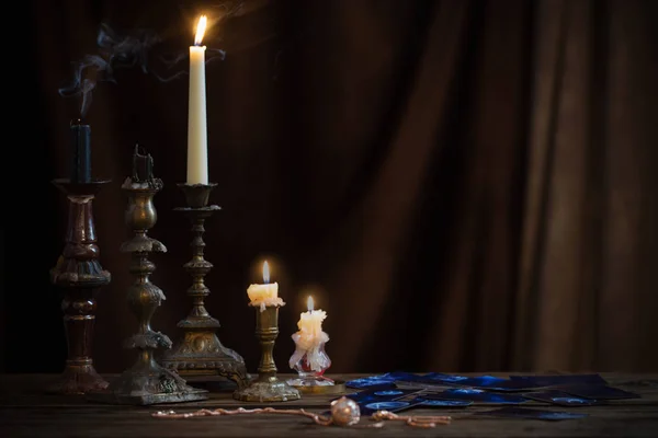 Cartões de adivinhação e velas ardentes em uma mesa de madeira em — Fotografia de Stock