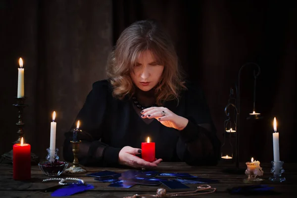 Mature witch  conjures on  dark background — Stock Photo, Image