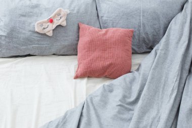 Gri çarşaflı yatak ve uyku maskesi 