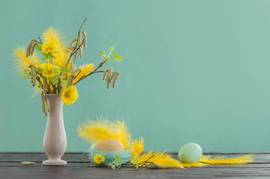 Yeşil arka planda Paskalya yumurtaları ve bahar çiçekleri 