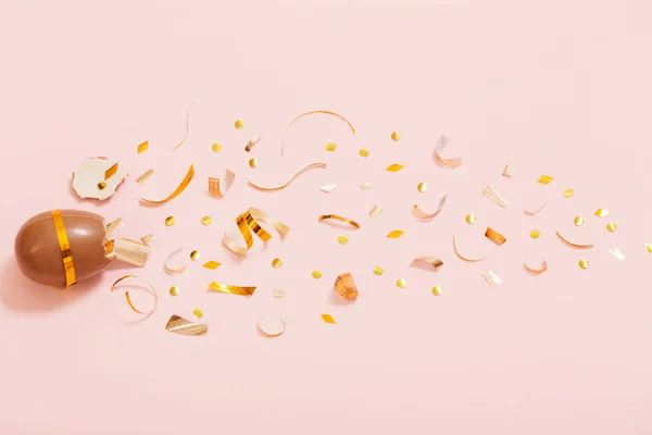 Pasen chocolade ei met gouden confetti op roze achtergrond — Stockfoto