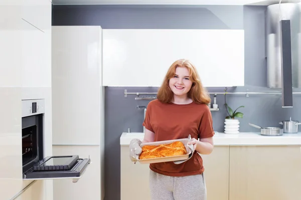 Χαρούμενο κορίτσι φτιάχνει πίτα σε μοντέρνο λευκό kithen — Φωτογραφία Αρχείου