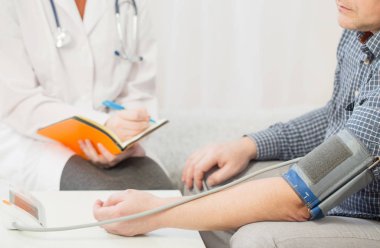 Doktor ve hasta kan basıncını, sağlık hizmetlerini ve konukseverliği ölçüyor.