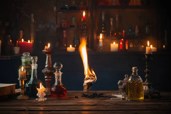 Old burning paper with potions on old wooden table — Stock Photo, Image
