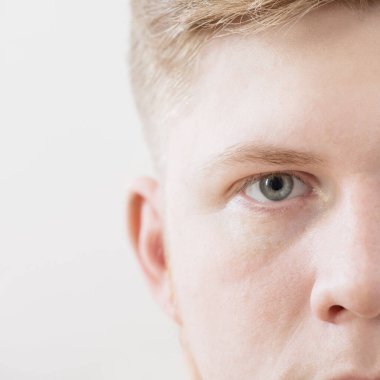 Beyaz arka planda genç bir adamın yarı yüzü