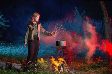 gece ormanda yangın genç cadı sihirli iksir hazırlar